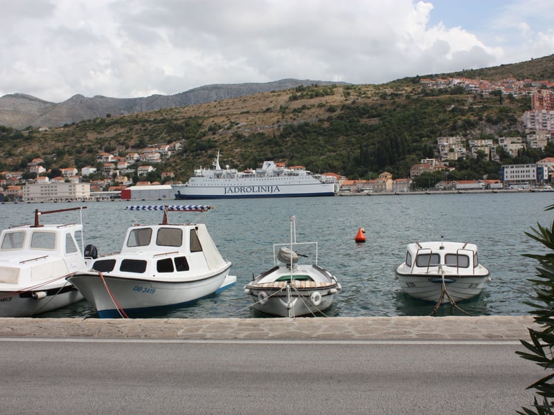 Small boats on the quay of Gruž harbour in Dubrovnik, with a Jadrolinija ferry at the port behind