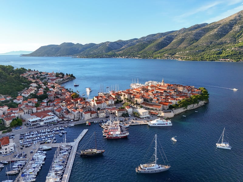 Aerial view of Korčula's walled old town on its peninsula, with the Pelješac hills across the channel