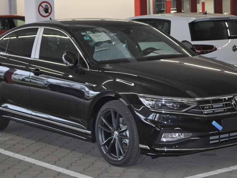 A black Volkswagen Passat saloon, the model of our standard car with a driver